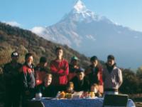 Young trekkers enjoy breakfast with local staff , the beautiful peak of Machapuchare in the backdrop |  <i>Sue Badyari</i>